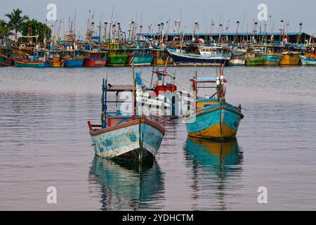 Port maritime dans la baie de Mirissa au Sri Lanka avec des bateaux colorés et des navires sur la mer bleue. Banque D'Images