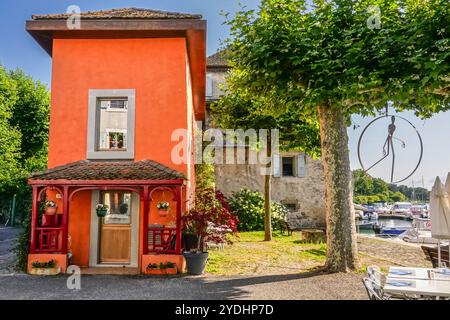 Une maison aux couleurs vives à côté du jardin au bord du lac dans le petit village médiéval de Nernier, le long de la rive française du lac Léman à Nernier, haute Savoie, France. Banque D'Images