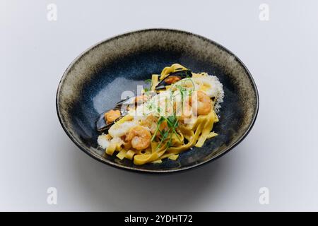 Pâtes de fruits de mer crémeuses avec crevettes, moules et parmesan, choix élégant pour les moments gastronomiques Banque D'Images