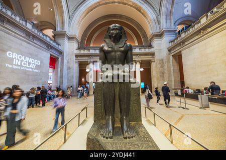 Ancienne statue égyptienne de pharaon exposée dans le grand hall Metropolitan Museum of Art entouré de visiteurs et d'arches. New York. ÉTATS-UNIS. Banque D'Images