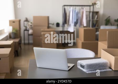 Ordinateur portable sur la table avec des effets personnels dans des boîtes au nouveau magasin Banque D'Images