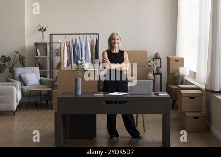 Fière femme âgée propriétaire de magasin de vêtements sur Internet regarder la caméra Banque D'Images