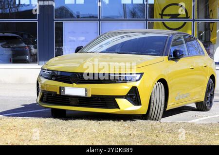 Nouvelle Opel Astra jaune garée devant un concessionnaire. La nouvelle 6e génération d'Astra est disponible avec entraînement électrique. Salo, Finlande. 10 avril 2023 Banque D'Images