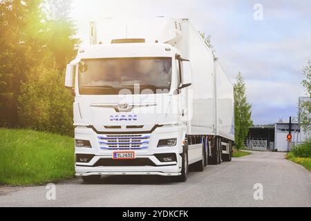 Blanc, nouveau camion MAN TGX 26,510 devant une remorque réfrigérée garée sur la cour asphaltée à la lumière de l'heure d'or. Salo, Finlande. 29 mai 2022 Banque D'Images