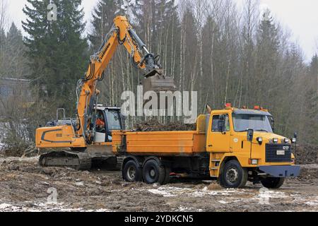 FORSSA, FINLANDE, 28 JANVIER 2017 : la pelle sur chenilles Liebherr R 918 charge le sol sur le camion à bascule Sisu SR 332 jaune en hiver Banque D'Images