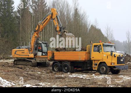 FORSSA, FINLANDE, 28 JANVIER 2017 : la pelle sur chenilles Liebherr R 918 charge le sol sur le camion à bascule Sisu SR 332 jaune en hiver Banque D'Images