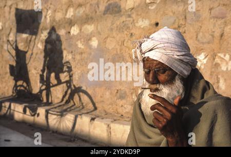 12.03.2010, Haridwar, Uttarakhand, Inde, Asie, un homme âgé fume une cigarette sur le bord de la route pendant la fête religieuse hindoue de Kumbh Mela, Un Banque D'Images