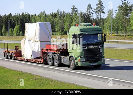 Vert Scania R580 semi-remorque transporte l'objet industriel couvert de bâche comme charge longue sur l'autoroute d'été par une journée ensoleillée. Salo, Finlande, 18 mai 2018, E Banque D'Images