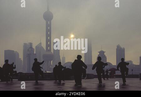 13.02.2005, Shanghai, République populaire de Chine, Asie, exercices de Tai Chi tôt le matin avec une vue du Bund à travers la rivière Huangpu à t Banque D'Images