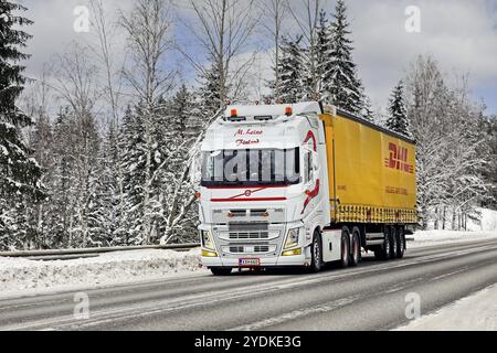 Camion Volvo FH blanc magnifiquement personnalisé M. Leino tire une remorque de fret DHL sur l'autoroute 52 par jour froid de l'hiver. Salo, Finlande. 12 février 2021 Banque D'Images