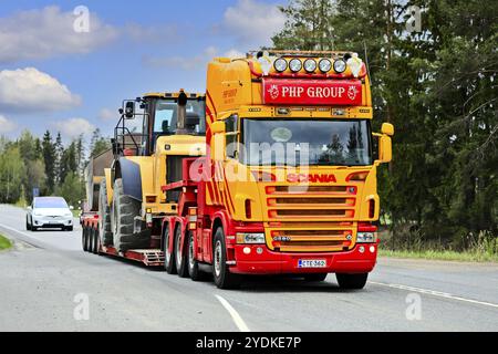 Le camion SCANIA G580 personnalisé du groupe PHP devant la remorque en col de cygne transporte une chargeuse sur pneus Cat sur l'autoroute 2. Jokioinen, Finlande. 14 mai 2021 Banque D'Images