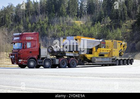 Red Scania Truck Lavettikuljetus Alanne Oy tire Keestrack B5 Jaw Crusher sur semi-remorque à plateau bas. Charge large. Forssa, Finlande. 29 avril 2021 Banque D'Images