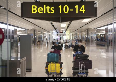 18.03.2020, Singapour, République de Singapour, Asie, deux voyageurs aériens portent un masque à leur arrivée au terminal 1 de l'aéroport de Changi pour se protéger fr Banque D'Images