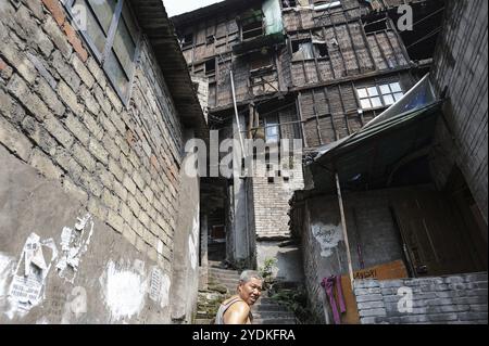 04/08/2012, Chongqing, Chine, Asie, Un homme grimpant un vieil escalier en pierre dans la zone des dix-huit escaliers, devant des maisons traditionnelles dans la vieille ville de la Banque D'Images