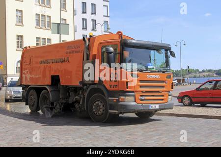 La balayeuse de route Orange Scania P340 nettoie les rues de la ville dans la circulation lors d'une journée ensoleillée de printemps à Helsinki, Finlande, le 24 mai 2018, Europe Banque D'Images