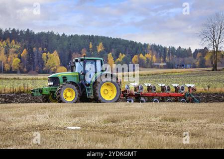 Agriculteur labourant un champ de chaume avec le tracteur John Deere 7530 et charrue un jour d'automne. Salo, Finlande. 13 octobre 2022 Banque D'Images