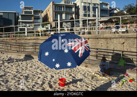 21/09/2018, Sydney, Nouvelle-Galles du Sud, Australie, Une femme est assise sur Bondi Beach sous un parasol avec le drapeau national australien imprimé dessus, Océanie Banque D'Images