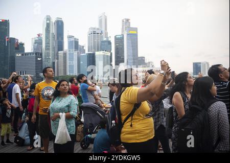 04.08.2018, Singapour, République de Singapour, Asie, les visiteurs regardent une manœuvre aérienne locale au-dessus de Marina Bay contre le dos imposant Banque D'Images