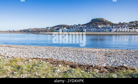 Une longue rangée de grandes maisons bordent le front de mer à Deganwy sur la côte nord du pays de Galles photographiée à travers l'estuaire de Conwy. Banque D'Images