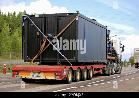 Orivesi, Finlande, 27 août 2018 : semi-camion blanc transporte un conteneur large sur une remorque Noteboom sur l'autoroute entre autres camions, vue arrière, Europe Banque D'Images