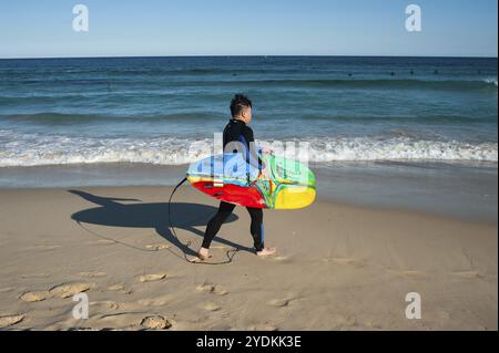 21.09.2018, Sydney, Nouvelle-Galles du Sud, Australie, Un surfeur marche avec sa planche de surf sous le bras vers la mer à Bondi Beach, Océanie Banque D'Images