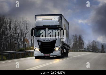 Le nouveau camion blanc Iveco S-Way tire une semi-remorque sur l'autoroute 52 à la lumière spectaculaire de la fin de l'automne. Salo, Finlande. 28 octobre 2022 Banque D'Images