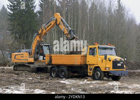 FORSSA, FINLANDE, 28 JANVIER 2017 : la pelle sur chenilles Liebherr R 918 charge le sol sur le camion à bascule Sisu SR 332 jaune en hiver Banque D'Images