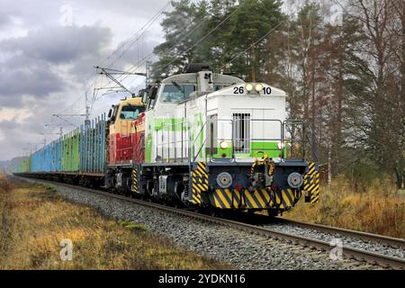 Train de marchandises VR avec deux locomotives diesel et des wagons pleins de bûches de bois en mouvement un jour d'automne. Humppila, Finlande. 30 octobre 2020 Banque D'Images