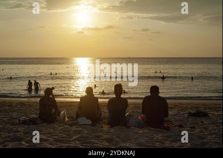 18.11.2019, Phuket, Thaïlande, Asie, les touristes s'assoient dans le sable et profiter du coucher de soleil sur la plage de Karon, une destination populaire pour les touristes russes, l'Asie Banque D'Images