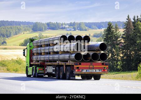 Un camion vert citron Scania devant une semi-remorque transporte des tuyaux métalliques le long de l'autoroute pendant un jour d'été. Vue arrière. Pirkanmaa, Finlande. 11 août 2022 Banque D'Images