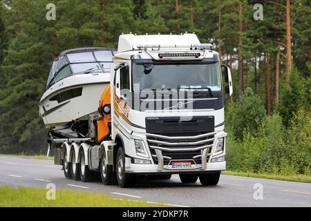 Le camion Volvo FH magnifiquement personnalisé de Tobblift transporte un bateau de plaisance sur l'autoroute 52 le jour de l'automne. Salo, Finlande. 4 septembre 2020 Banque D'Images