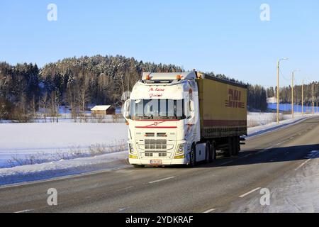 Camion Volvo FH blanc magnifiquement personnalisé M. Leino tire une remorque de fret DHL sur l'autoroute 52 par jour ensoleillé de l'hiver. Salo, Finlande. 12 février 2021 Banque D'Images