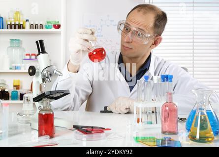 Un jeune scientifique menant des expériences avec des réactifs chimiques dans un laboratoire chimique Banque D'Images