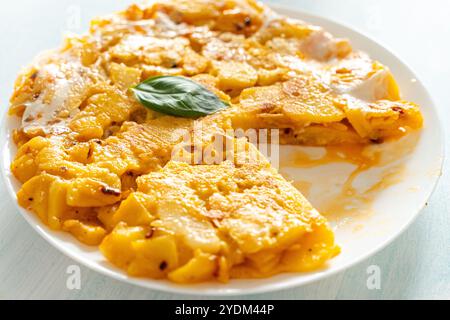 Omelette espagnole ou Tortilla de patata, avec pommes de terre et oignons, sur une assiette, une pièce coupée. Cuisine espagnole typique. Photo de haute qualité Banque D'Images