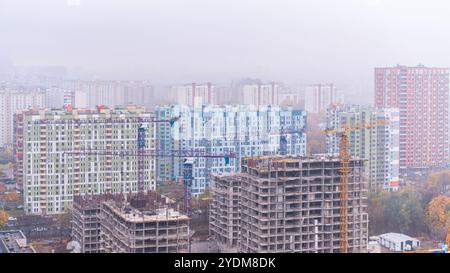 Moscou, Russie - 18, 2024 : construction de bâtiments résidentiels à plusieurs étages sur fond de panorama de la ville dans le brouillard d'un oiseau' Banque D'Images