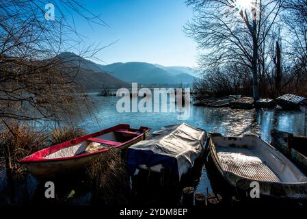 Gros plan de parties de petits bateaux de pêche abandonnés et couverts de mousse dans les eaux gelées du lac Fimon à Vicence Banque D'Images