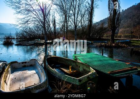 Gros plan de parties de petits bateaux de pêche abandonnés et couverts de mousse dans les eaux gelées du lac Fimon à Vicence Banque D'Images