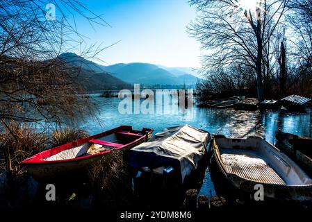 Gros plan de parties de petits bateaux de pêche abandonnés et couverts de mousse dans les eaux gelées du lac Fimon à Vicence Banque D'Images