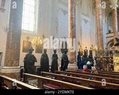 Innsbruck, Autriche - septembre 29 2024 : photo intérieure de Hofkirche avec des statues de bronze et des visiteurs âgés assis dans des bancs Banque D'Images