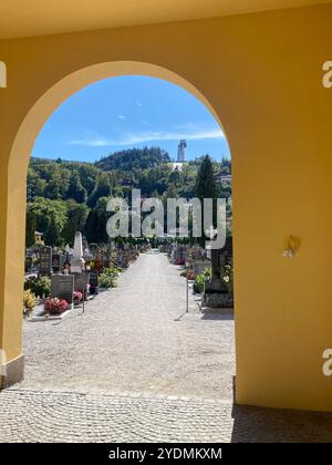 Innsbruck, Autriche, septembre 30 2024 : paisible cimetière Wilten avec Archway View et saut à ski Bergisel au loin Banque D'Images