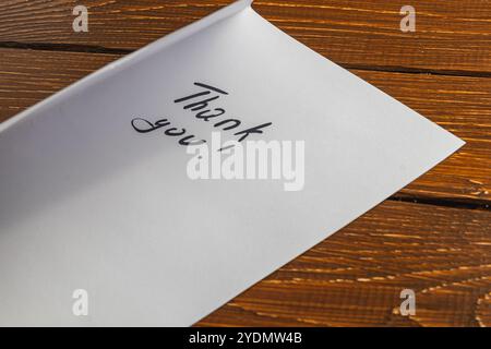 Une personne a écrit des mots de remerciement sur un morceau de papier sur la table Banque D'Images