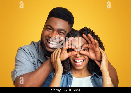 Joyeux petit ami noir faire des lunettes drôles à rire petite amie Banque D'Images