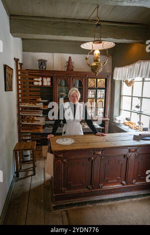 Scène de boulangerie historique avec Baker dans l'intérieur de la boutique vintage Banque D'Images