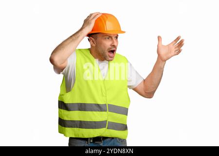 Angry Construction Foreman travailleur criant en touchant HardHat debout, Studio Shot Banque D'Images