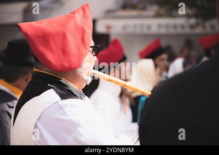 Ibiza, Espagne - 8 octobre 2023 : musicien en tenue traditionnelle basque jouant de la flûte lors d'un festival culturel dans la vieille ville d'Ibiza, mettant en valeur vibrant Banque D'Images