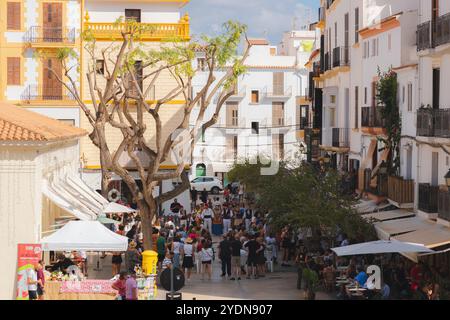 Ibiza, Espagne - 8 octobre 2023 : scène de rue animée dans la ville d'Ibiza, capturant un festival local dynamique avec des gens se rassemblant sous le su méditerranéen Banque D'Images