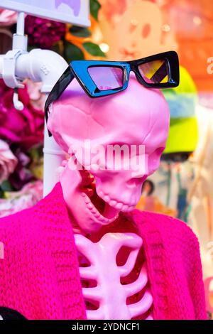 Un squelette de mannequin rose portant des lunettes de soleil noires élégantes et une veste rose éclatante dans un magasin urbain coloré de nyc usa Banque D'Images