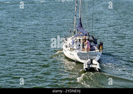 Veere, Zeeland, pays-Bas - 10 août 2022 : personnes sur un yacht remorquant un canot roulant vers la ville de Veere. Banque D'Images