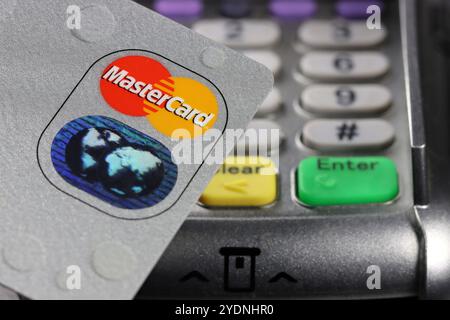 Logo MasterCard sur carte de crédit avec terminal de paiement en arrière-plan Banque D'Images
