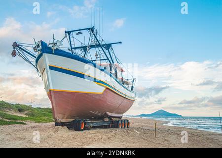Navegantes-SC,brésil-octobre 25,2024 bateau ancré dans le sable de la ville en fin d'après-midi avec vue sur la montagne de Penha SC dans le backgr Banque D'Images